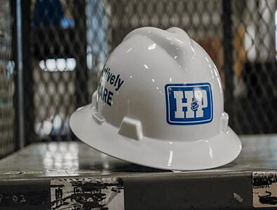 A white H&P hard hat sitting on a table.
